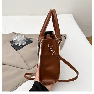 Détail du sac bicolore avec bandoulière en similicuir marron et foulard décoratif en soie