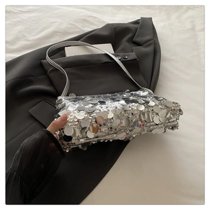 Close-up of silver sequin shoulder bag with metallic round discs and slim silver strap