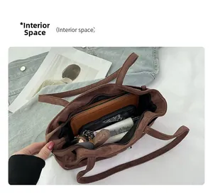 Top view showing spacious interior of brown suede tote bag with daily essentials inside