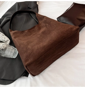 Close-up of brown matte suede tote bag showing soft texture and wide shoulder strap