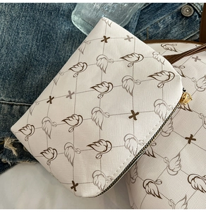 Close-up of white crossbody bag featuring crosshatch texture and swan pattern detail