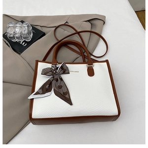 Détails du sac blanc texture serpent avec poignées en cuir marron et foulard en soie