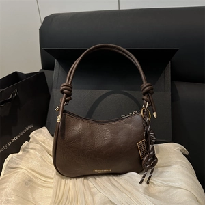 Vintage dark brown crossbody bag with pleated texture and tassel in a studio setting