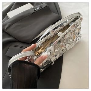 Detailed close-up of large silver sequins and metal zipper on this chic party clutch bag