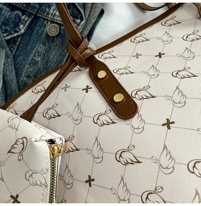 Close-up of printed tote bag showing swan pattern and textured cross-grain faux leather
