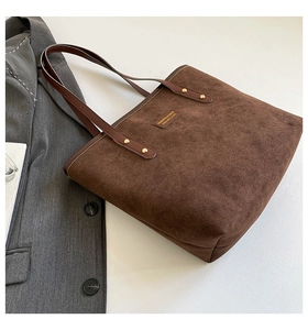 Detailed top view of large brown suede tote bag with leather straps and metal rivets