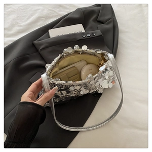 Close-up of silver sequin bag interior showing phone, card holder and makeup items