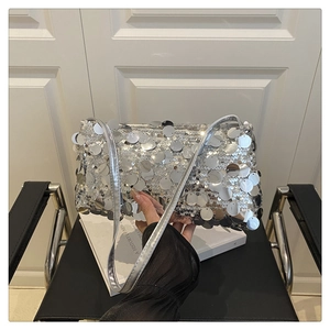 Detailed view of silver sequin shoulder bag with reflective metallic disks and strap