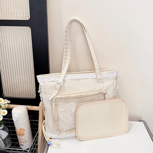 Creamy white ita bag with lace trim and clear window for badges in a lifestyle setting