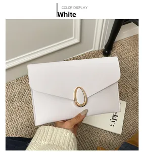 Close-up of a white envelope clutch bag with a textured finish and gold oval metal buckle