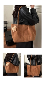 Détail d'un grand sac cabas en daim marron avec un joli porte-clés en peluche d'ourson