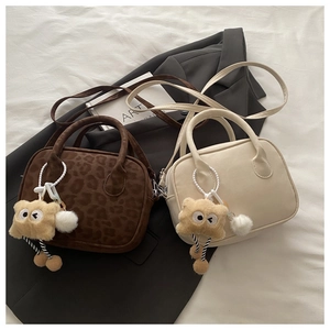 Detail of mini square handbags in leopard and off-white with furry monster charms