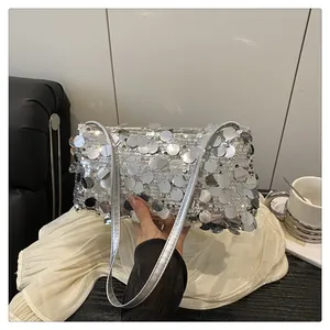 Detail of silver sequin shoulder bag with large reflective circular discs and strap