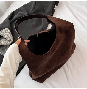 Macro view of a dark brown vintage suede tote bag with large capacity and magnetic closure