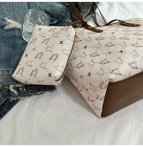 Detail of printed tote bag and pouch set with bird pattern and brown leather accents