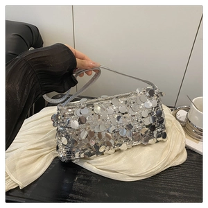 Detailed close-up of large silver sequins and metallic texture on a luxury handbag