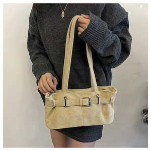Detail of beige suede underarm bag with metal buckle and long double shoulder straps