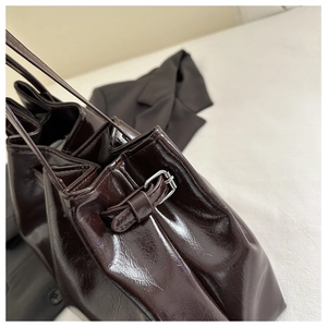 Close-up of shiny dark brown oil wax leather texture and adjustable silver metal buckle