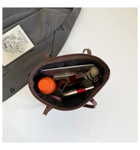 Interior view of large leather tote bag showing spacious capacity for tablets and cosmetics