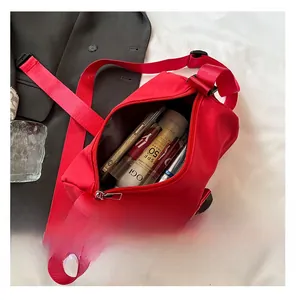 Top view of bright red nylon crossbody bag showing spacious interior with personal items