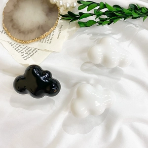 Close-up of cloud-shaped glossy phone grip sockets in black and white minimalist style