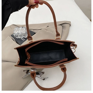 Overhead detail view showing the three spacious inner compartments and zipper of the tote bag