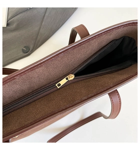 Close-up of golden zipper closure on brown tote bag with high-quality interior lining