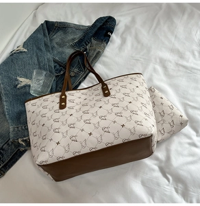 Detail of canvas tote bag and matching pouch with swan print and leather handles