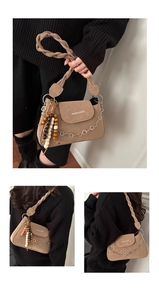 Detail view of woven shoulder strap and decorative metal chain on the apricot square bag