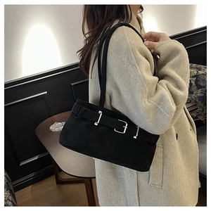 Detail of black suede shoulder bag featuring silver metal buckle and textured finish