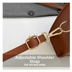 Detailed close-up of brown leather strap with adjustable golden buckle and lobster clasp