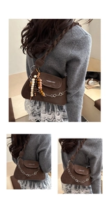 Detail of vintage brown matte leather bag with flower chain and wooden bead tassels