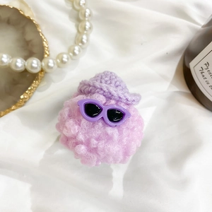 Close-up of purple crochet plush doll featuring black sunglasses and a stylish pointed hat