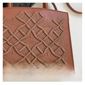 Detailed close-up of caramel brown leather with diamond embroidery and crown accents