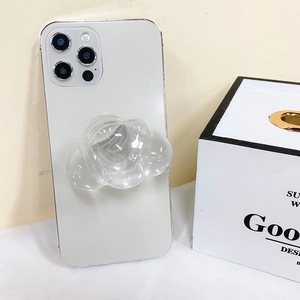 Detailed view of a transparent cloud-shaped phone grip attached to a white smartphone