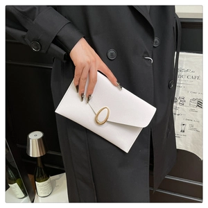 Close-up of elegant white envelope clutch bag with oval gold buckle for evening
