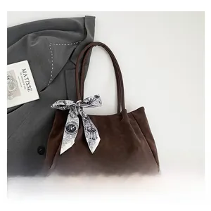 Détail du grand sac fourre-tout en daim marron foncé avec foulard en soie décoratif chic