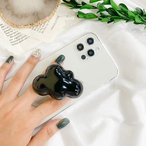 Glossy black cloud-shaped phone socket stand shown on a white smartphone in hand