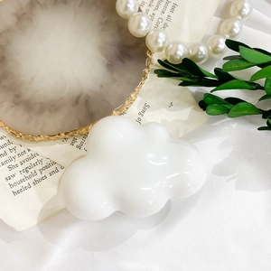 Detailed view of the sleek white cloud-shaped phone grip on an elegant background