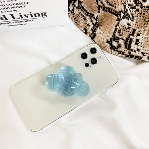 Detail of a translucent blue cloud phone grip on a white case with a clean aesthetic