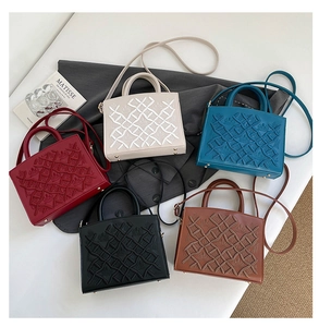 Detailed close-up of vintage embroidered tote bags in five colors with textured leather