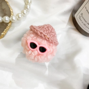 Close-up of pink plush doll phone grip with tiny knitted hat and sunglasses detail