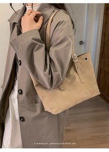 Elegante borsa tote in finta pelle scamosciata beige con occhielli indossata da modella