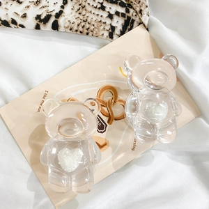 Detailed macro view of two transparent bear-shaped phone grips with white plush hearts
