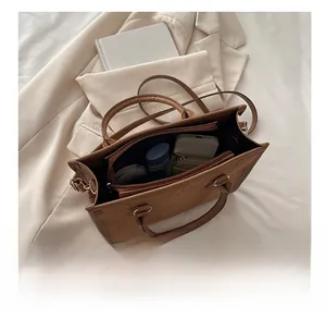 Vista interna della borsa tote in pelle marrone con scomparti e tasca con zip