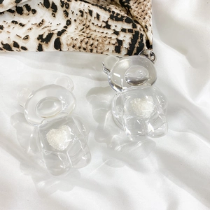Close-up of two transparent resin bear charms with white textured heart decoration