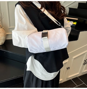 Close-up of white cylindrical Oxford crossbody bag with adjustable buckle and nylon strap