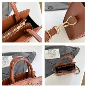 Detail of premium brown faux leather bag showing floral embroidery and gold metal hardware