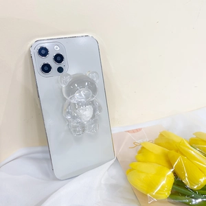 Detail of transparent bear-shaped phone grip with a white heart on a smartphone