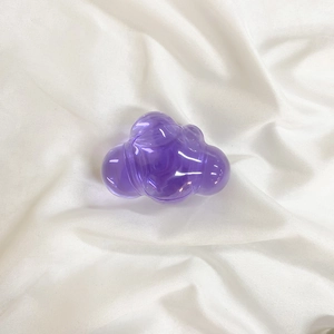 Macro view of transparent purple resin cloud-shaped phone socket on white silk fabric